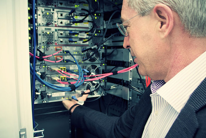 Neos IT Services, working environment, employee in front of a server rack