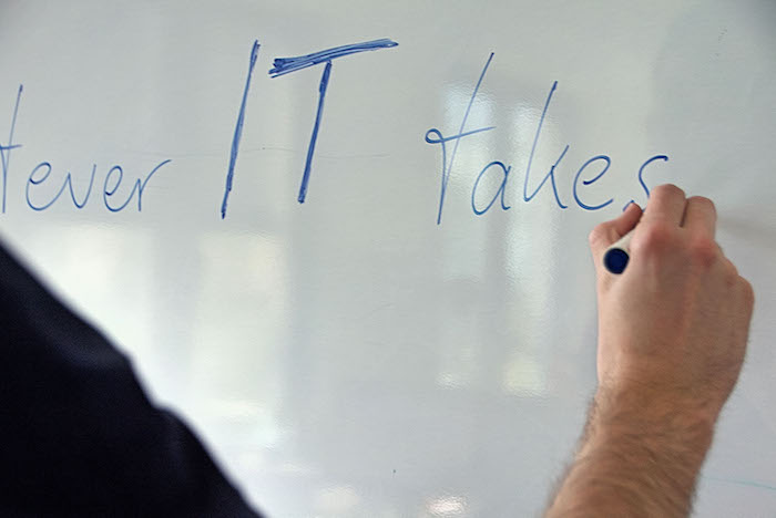 Neos IT Services, working environment, employee in front of a whiteboard